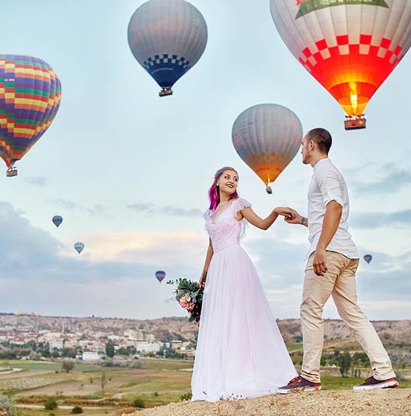Couple in love stands on background of balloons in Cappadocia.