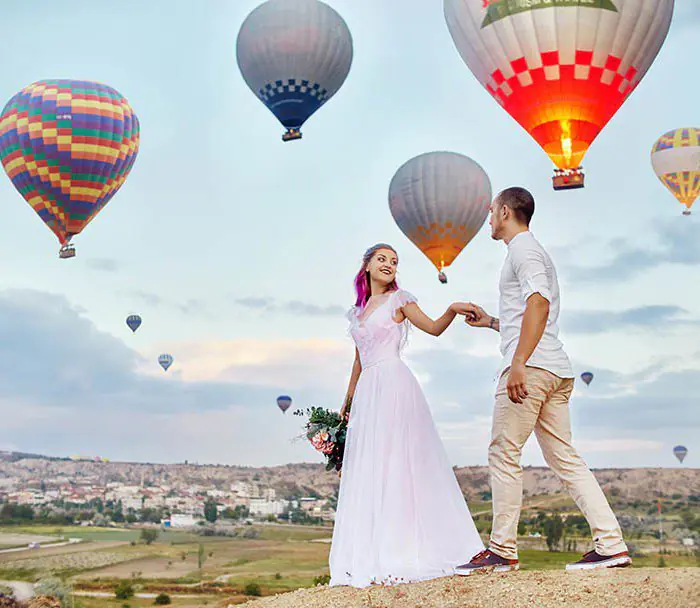 Couple in love stands on background of balloons in Cappadocia.