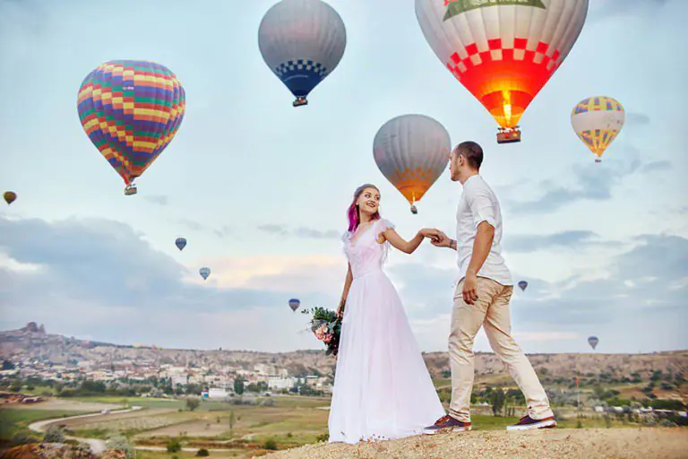 Couple in love stands on background of balloons in Cappadocia.