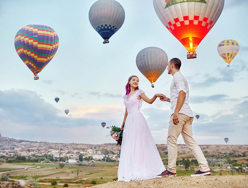 Couple in love stands on background of balloons in Cappadocia.
