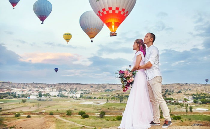 Man and woman hugging standing background of balloons in Cappadocia, Turkey.